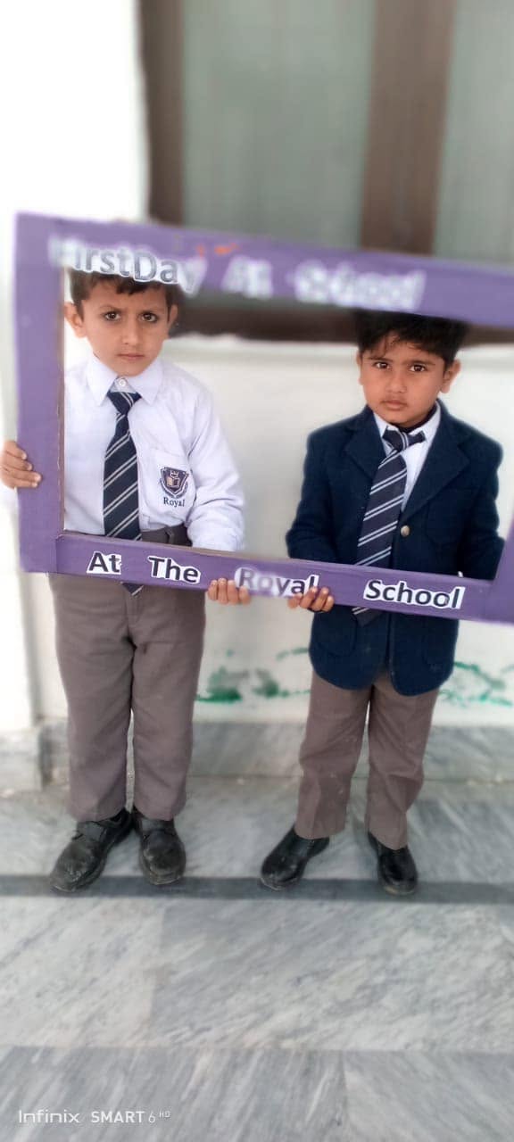 Royal School pupils posing with a First Day at School welcome frame