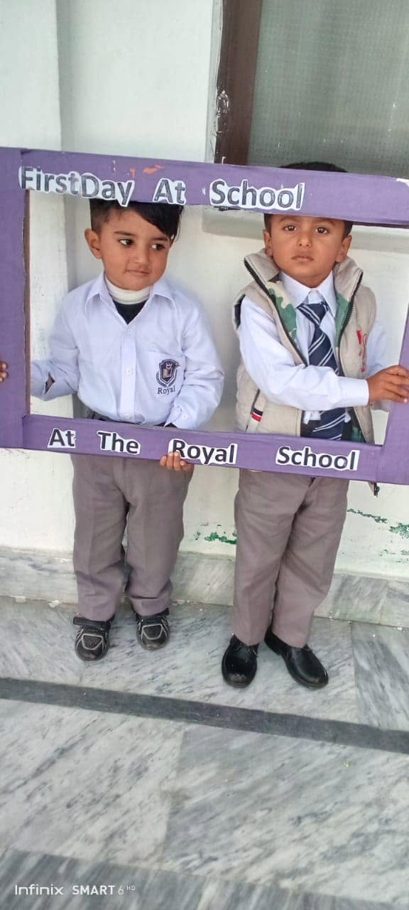 Royal School pupils posing with a First Day at School welcome frame